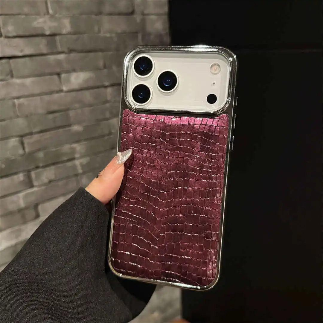 Phone case with purple crocodile texture held by a hand against a dark background
