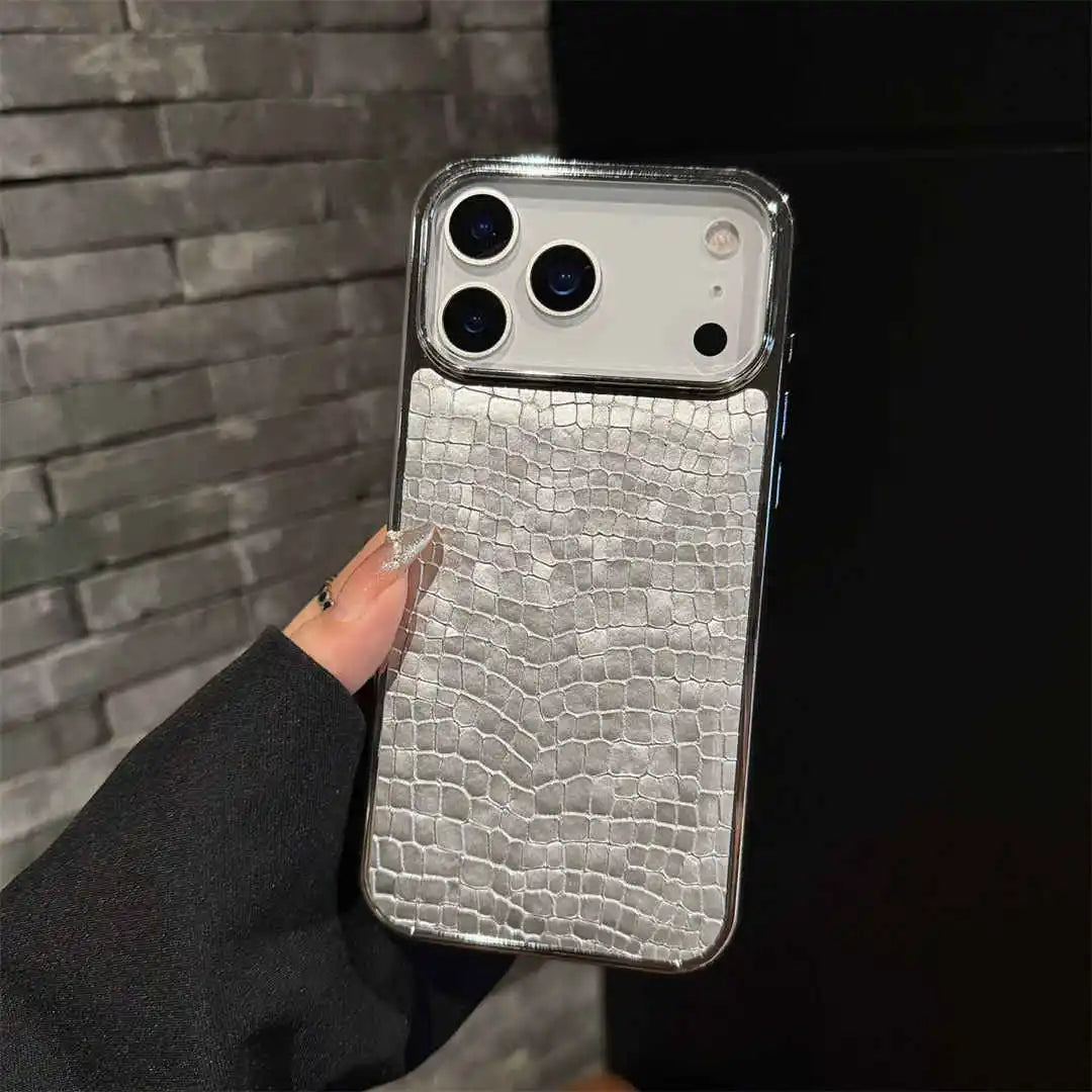 Phone case with crocodile texture held against a dark background