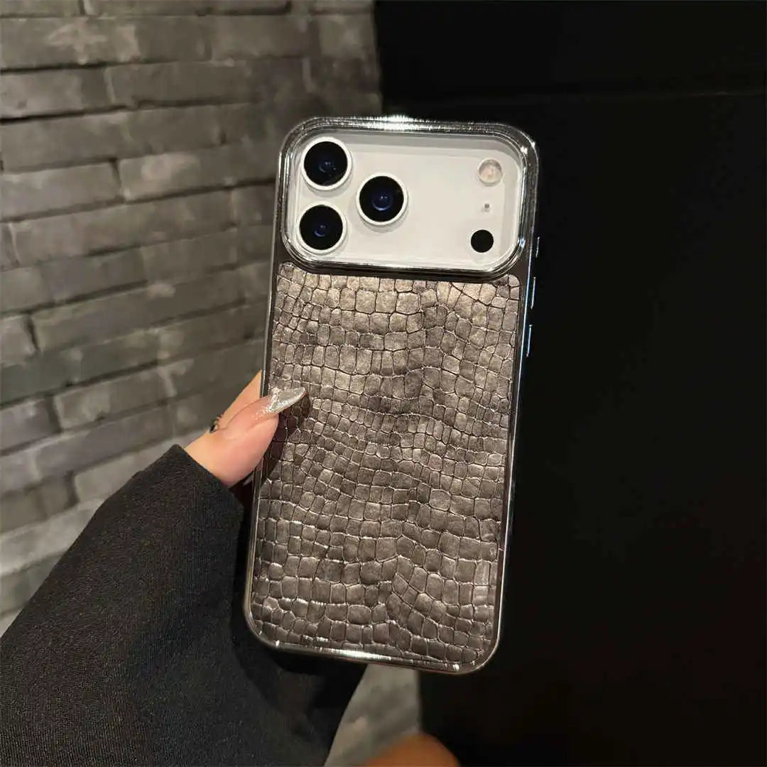 Phone case with crocodile texture held against a dark background