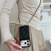 Person holding a black quilted phone case with a chain strap