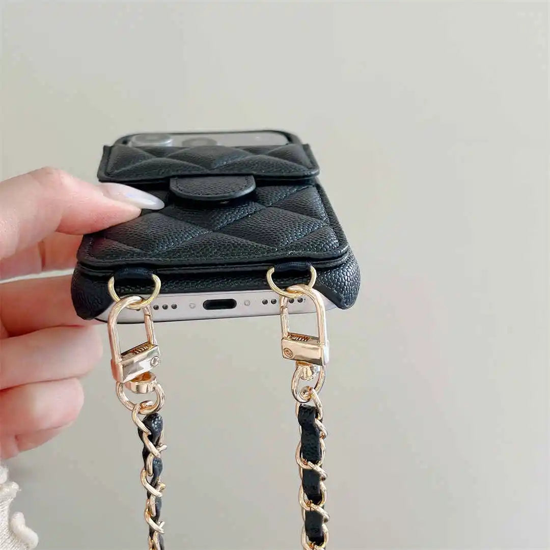Black phone case with flap and a chain strap held by a hand on a light gray background