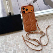 Brown quilted phone case with chain on a tiled floor