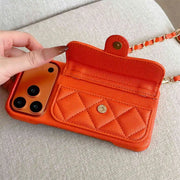 Orange quilted phone pouch held by a hand on a light gray surface