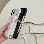 Phone case with chain strap held by a hand on a light background