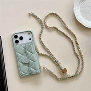 Mint green quilted phone case with a gold chain on a light background