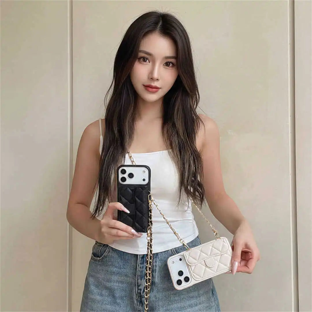 Woman holding a phone with a black case and a white quilted handbag against a plain background