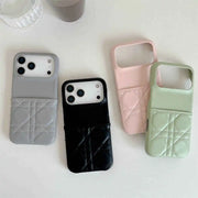 Four phone cases in gray, black, pink, and green on a light surface.