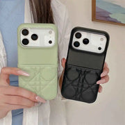 Two phone cases, one green and one black, held by a person against a neutral background.