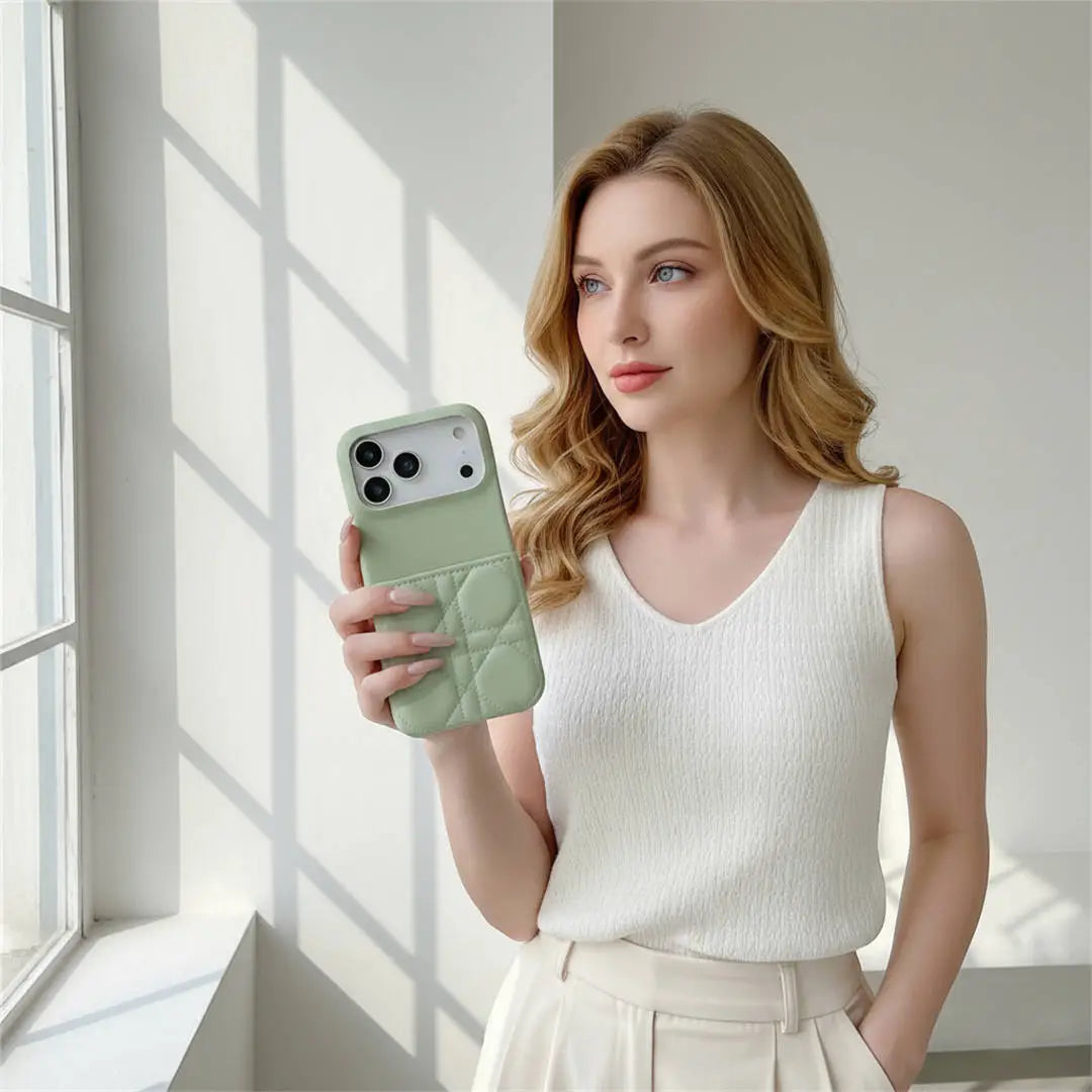 Woman holding a phone with a green case in a bright room