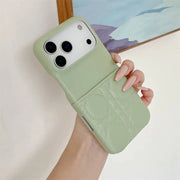 Hand holding a light green phone case with a subtle pattern against a neutral background