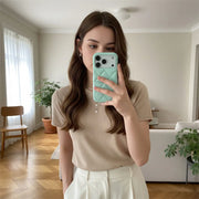 Woman taking a mirror selfie with a teal phone case in a home setting