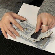 Person using a small electronic device on a white surface