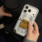 Person holding a phone case with a vintage design and a coffee cup in the background.