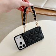 Black quilted phone case with chain strap held by a hand