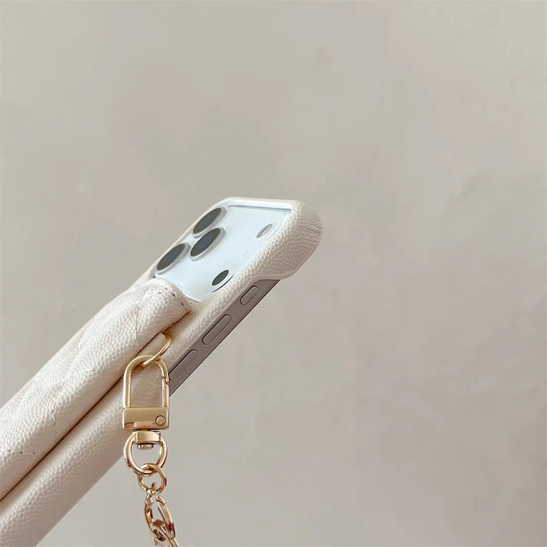 Phone case with a gold chain on a beige background