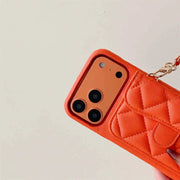 Orange quilted phone case with keychain on a light gray background