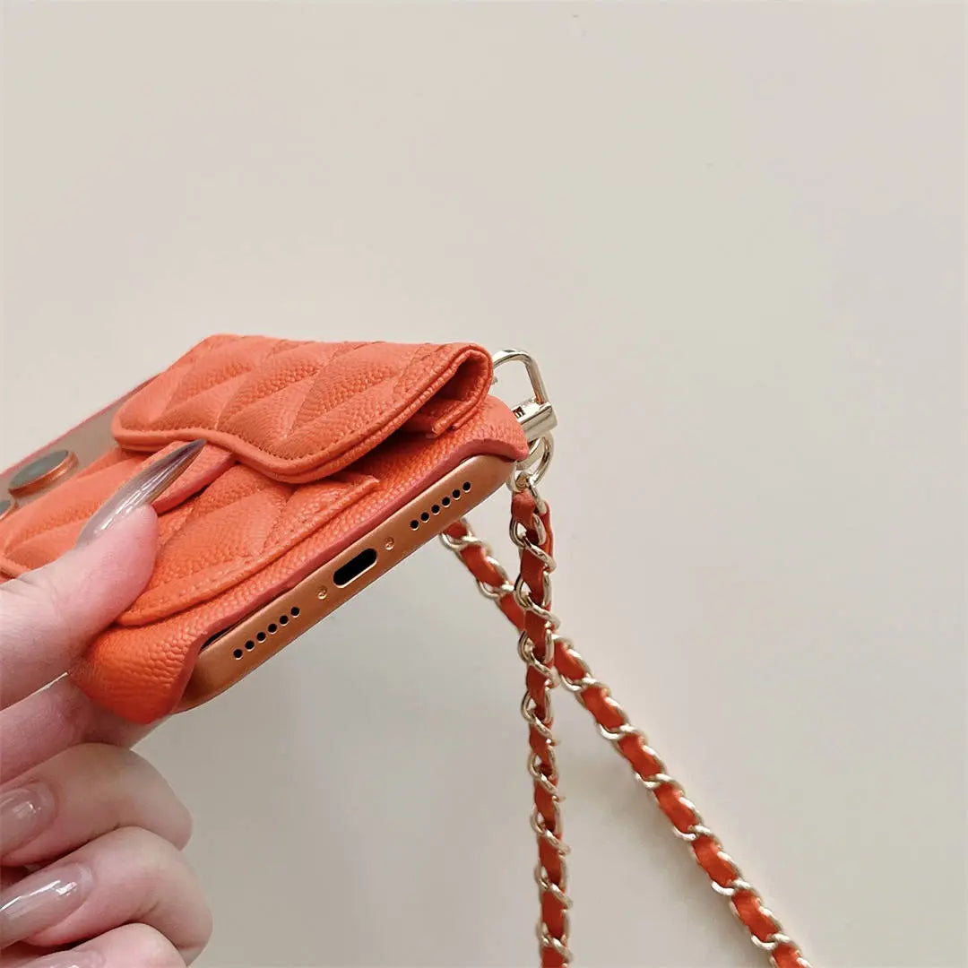 Orange phone case with chain strap held by a hand on a light background