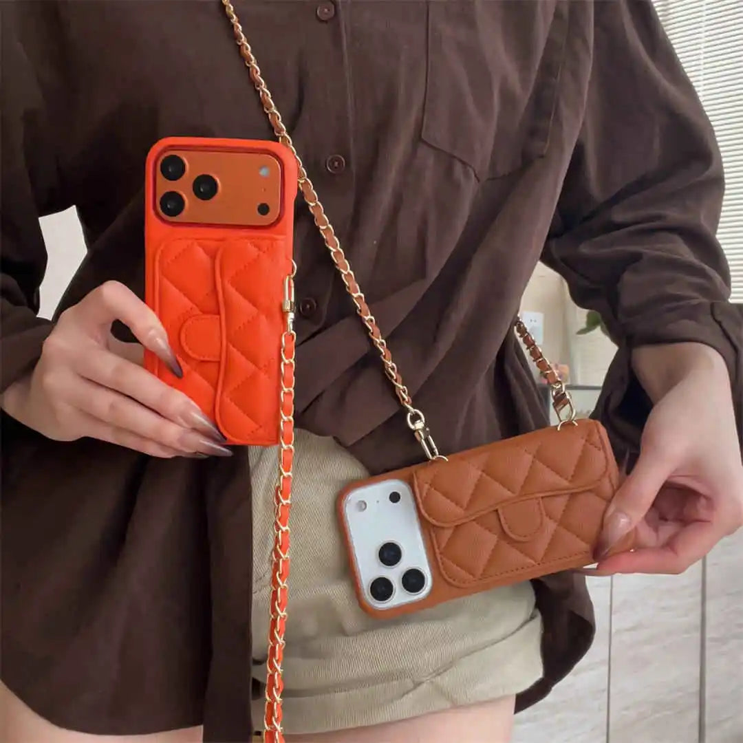 Person holding two orange and brown quilted phone cases with chain straps.