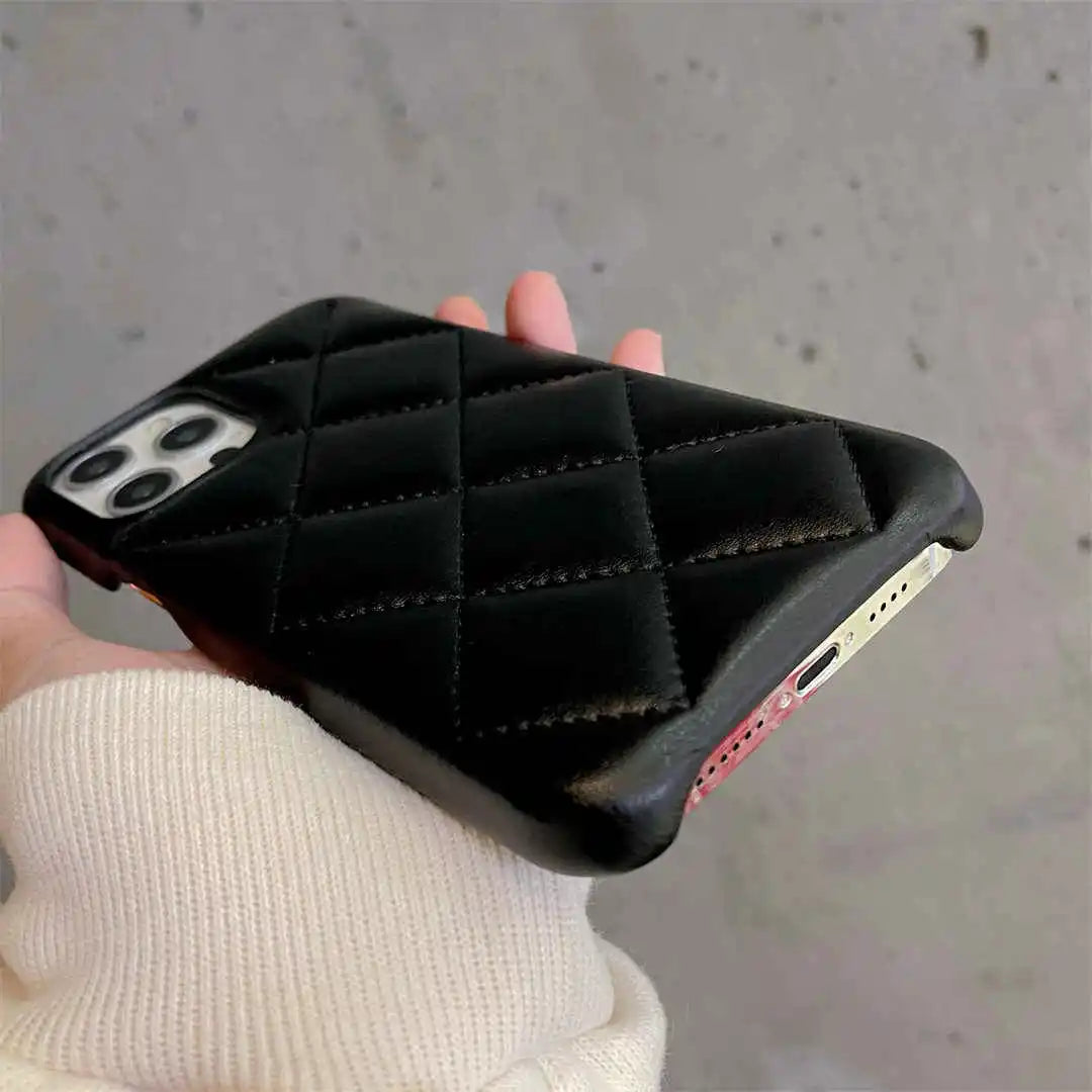 Black quilted phone case held by a person against a neutral background