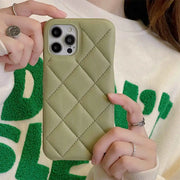 Person holding a green quilted phone case with a textured white and green background