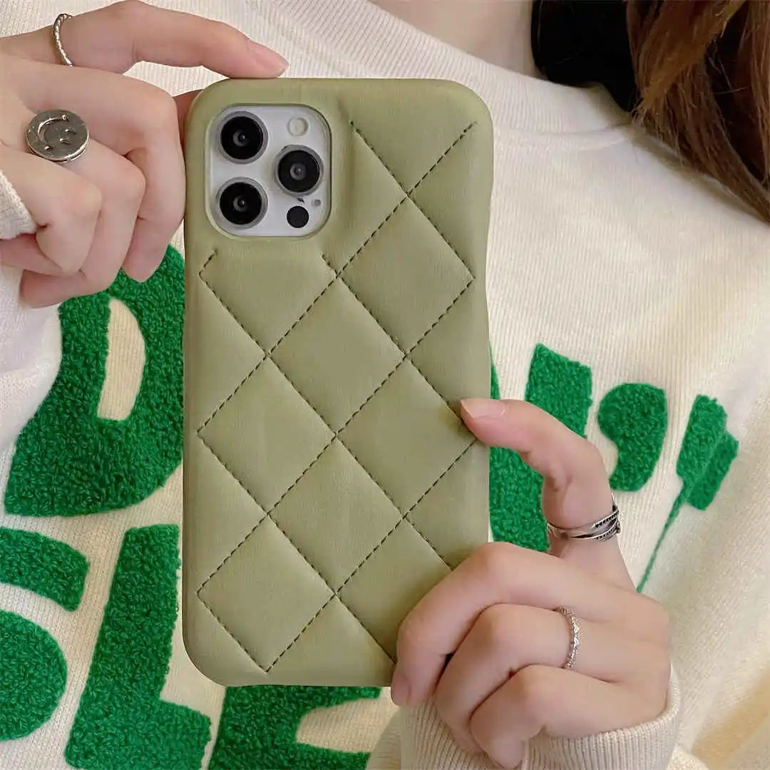 Person holding a green quilted phone case with a textured white and green background