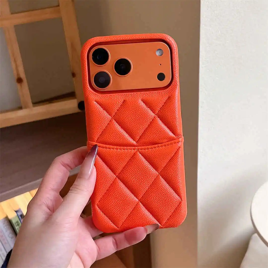 Orange quilted phone case held by a hand against a neutral background