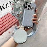 Phone case with detachable strap held by a hand, with blurred background